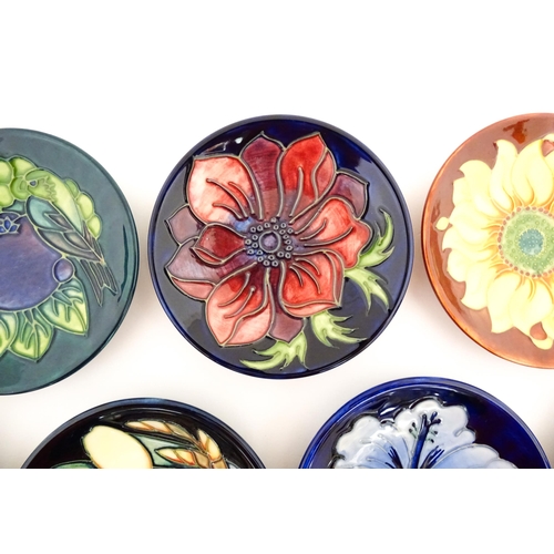 147 - Seven Moorcroft pin dishes / small plates decorated in various patterns to include Sunflower, Finche... 