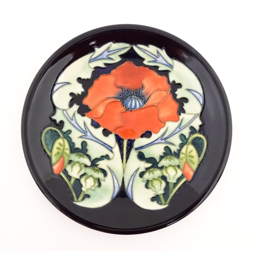 148 - A Moorcroft plate decorated in the Poppy plate designed by Rachel Bishop. Together with two oblong d... 