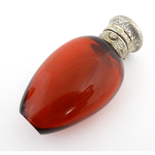 208 - A 19thC cranberry glass scent bottle / perfume flask with white metal top, maker GB. Approx. 3 1/2