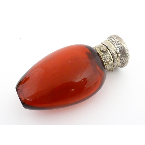 208 - A 19thC cranberry glass scent bottle / perfume flask with white metal top, maker GB. Approx. 3 1/2