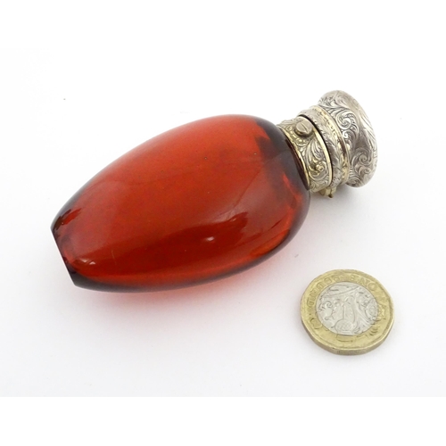 208 - A 19thC cranberry glass scent bottle / perfume flask with white metal top, maker GB. Approx. 3 1/2