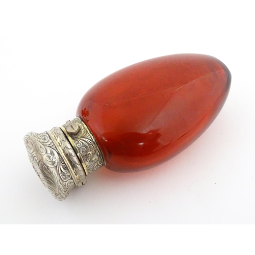 208 - A 19thC cranberry glass scent bottle / perfume flask with white metal top, maker GB. Approx. 3 1/2