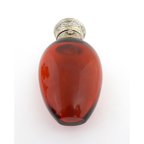 208 - A 19thC cranberry glass scent bottle / perfume flask with white metal top, maker GB. Approx. 3 1/2