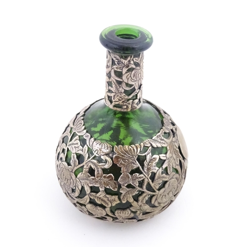 215 - A green glass perfume / scent bottle with white metal floral and foliate overlay in the Oriental sty... 