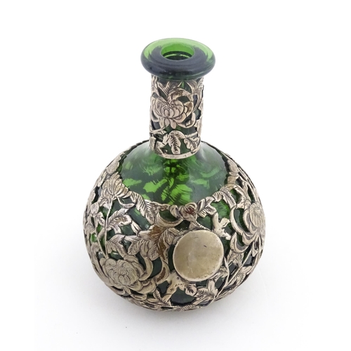 215 - A green glass perfume / scent bottle with white metal floral and foliate overlay in the Oriental sty... 