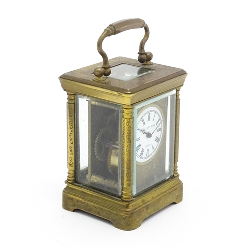 1436 - A small brass carriage clock with white enamel dial with Roman Numerals and signed ' Elliot & Son Lo... 