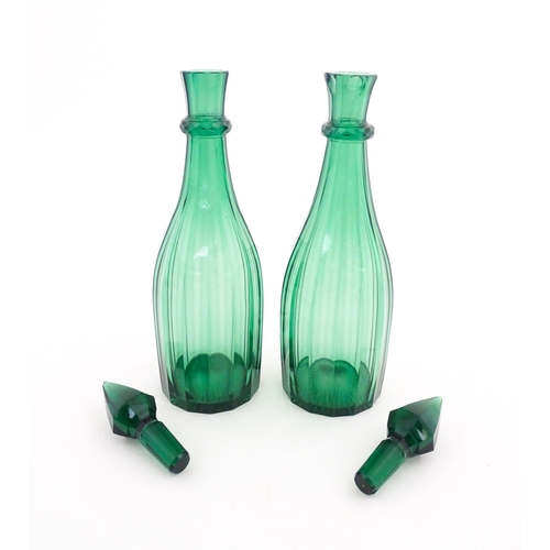 244 - A pair of 19thC green glass decanters and stoppers. Approx. 14