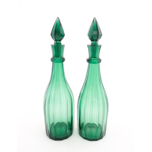 244 - A pair of 19thC green glass decanters and stoppers. Approx. 14