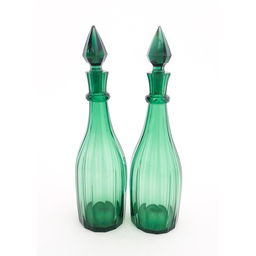 244 - A pair of 19thC green glass decanters and stoppers. Approx. 14