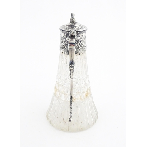 250 - A late 19th / early 20thC cut glass claret jug with silver plate mounts, the lid surmounted by a sty... 