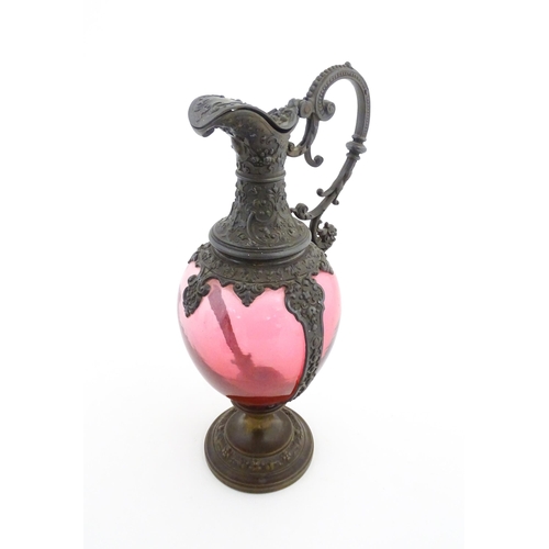 251 - A Victorian cranberry glass claret jug with decorative metal mounts and handle. Approx. 13