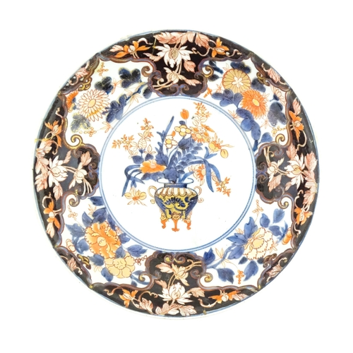 56 - A Japanese plate decorated in the Imari palette decorated with flowers and foliage, with further flo... 