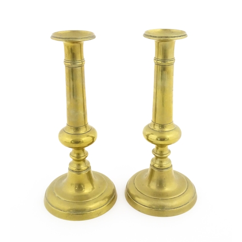 1104 - A pair of Victorian brass plunger candlesticks with knop detail to stems. Approx. 10 1/2