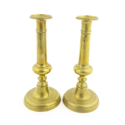 1104 - A pair of Victorian brass plunger candlesticks with knop detail to stems. Approx. 10 1/2