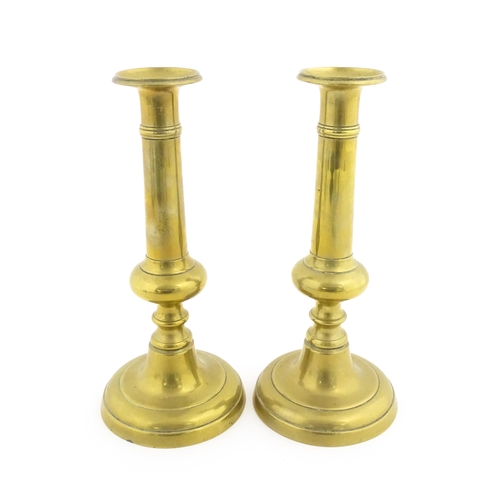 1104 - A pair of Victorian brass plunger candlesticks with knop detail to stems. Approx. 10 1/2