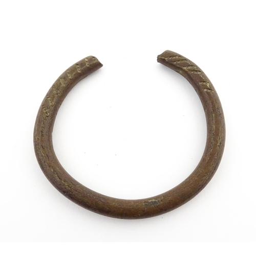 1123 - A manilla currency bracelet / bangle with incised detail. Approx. 2 1/2