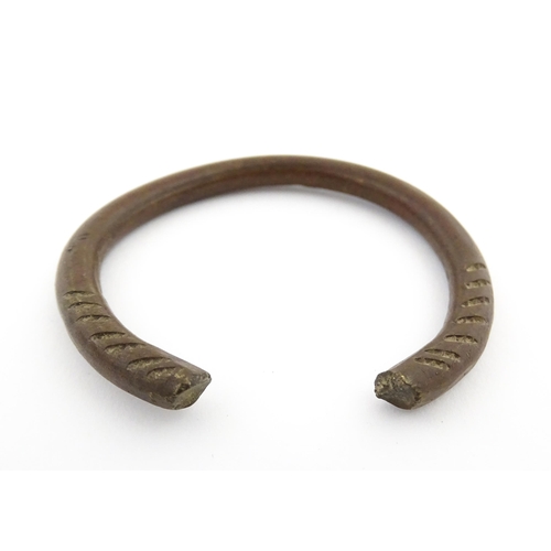 1123 - A manilla currency bracelet / bangle with incised detail. Approx. 2 1/2