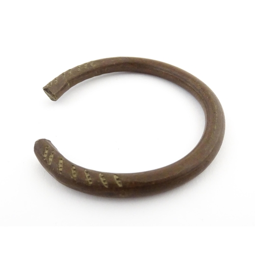 1123 - A manilla currency bracelet / bangle with incised detail. Approx. 2 1/2