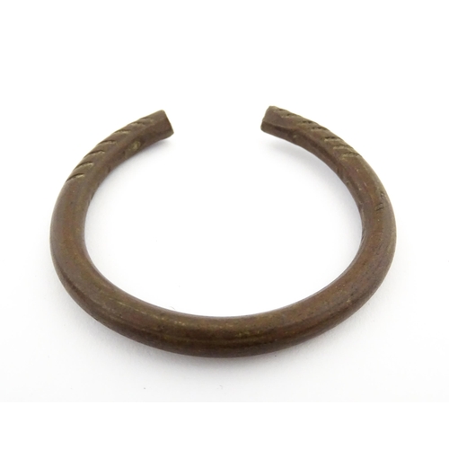 1123 - A manilla currency bracelet / bangle with incised detail. Approx. 2 1/2