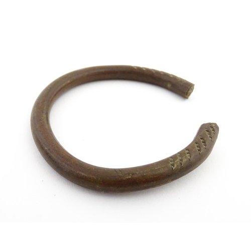 1123 - A manilla currency bracelet / bangle with incised detail. Approx. 2 1/2