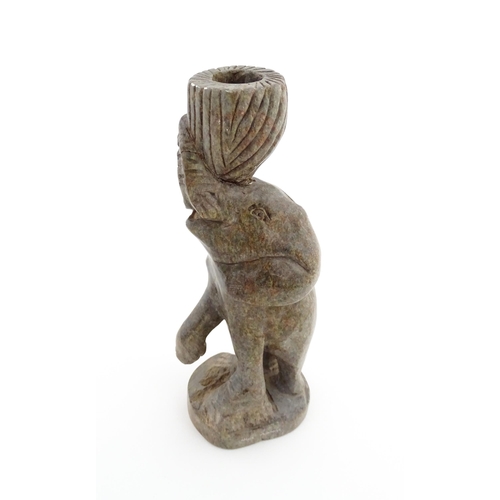 1130 - Ethnographic / Native / Tribal : An African carved soapstone candlestick formed as an elephant holdi... 