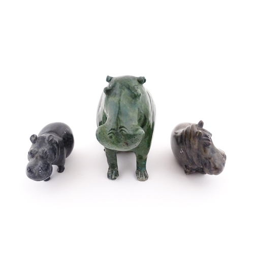 1133 - A carved hippo / hippopotamus and calf. Together with two carved soapstone hippos. Largest approx. 8... 