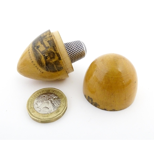 1149 - A 19thC Mauchline ware sewing thimble case of egg form with vignette depicting Carisbrooke Castle, c... 