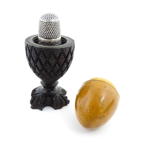 1152 - A 19thC treen / turned wooden thimble case and sewing thread holder of egg cup form, containing an e... 