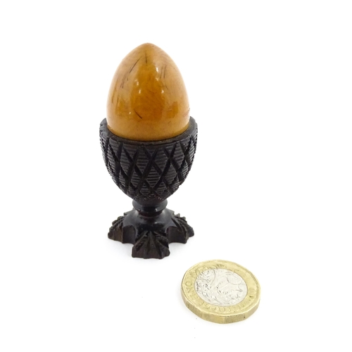 1152 - A 19thC treen / turned wooden thimble case and sewing thread holder of egg cup form, containing an e... 