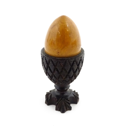 1152 - A 19thC treen / turned wooden thimble case and sewing thread holder of egg cup form, containing an e... 