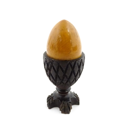 1152 - A 19thC treen / turned wooden thimble case and sewing thread holder of egg cup form, containing an e... 