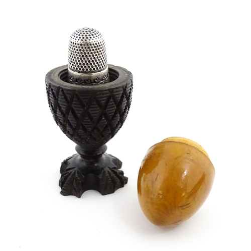 1152 - A 19thC treen / turned wooden thimble case and sewing thread holder of egg cup form, containing an e... 