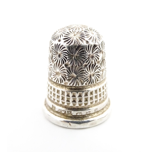 1153 - A 19thC carved coquilla nut of egg form with silver sewing thimble within, hallmarked Chester 1900, ... 