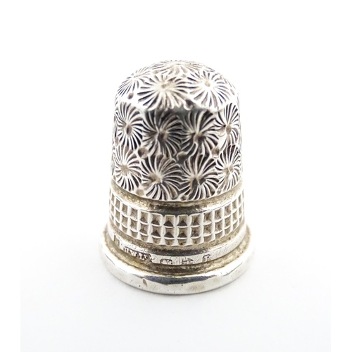 1153 - A 19thC carved coquilla nut of egg form with silver sewing thimble within, hallmarked Chester 1900, ... 