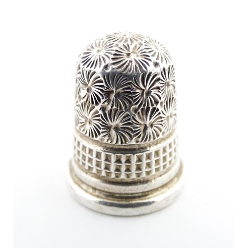 1153 - A 19thC carved coquilla nut of egg form with silver sewing thimble within, hallmarked Chester 1900, ... 