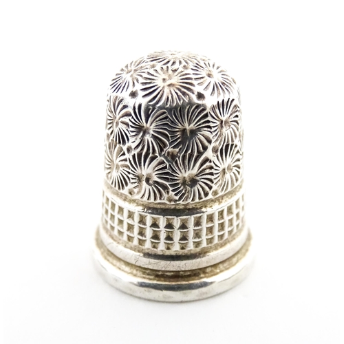 1153 - A 19thC carved coquilla nut of egg form with silver sewing thimble within, hallmarked Chester 1900, ... 