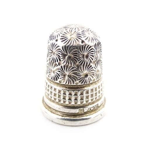 1153 - A 19thC carved coquilla nut of egg form with silver sewing thimble within, hallmarked Chester 1900, ... 