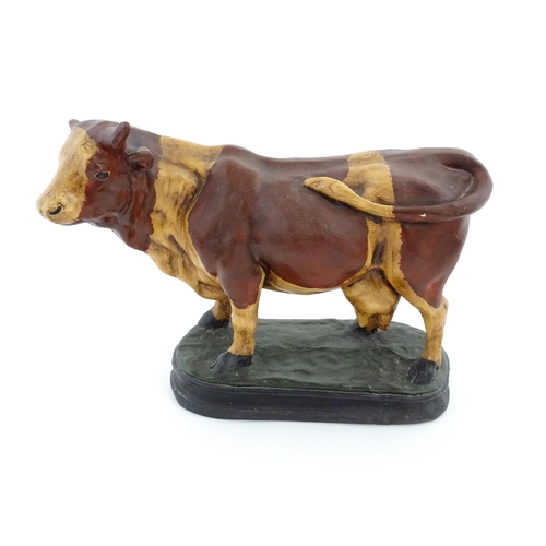 1264 - A 20thC fibreglass model of a cow with painted decoration. Approx. 13 1/4