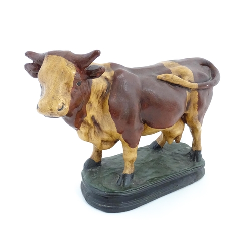 1264 - A 20thC fibreglass model of a cow with painted decoration. Approx. 13 1/4