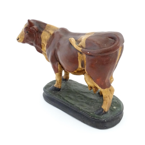 1264 - A 20thC fibreglass model of a cow with painted decoration. Approx. 13 1/4