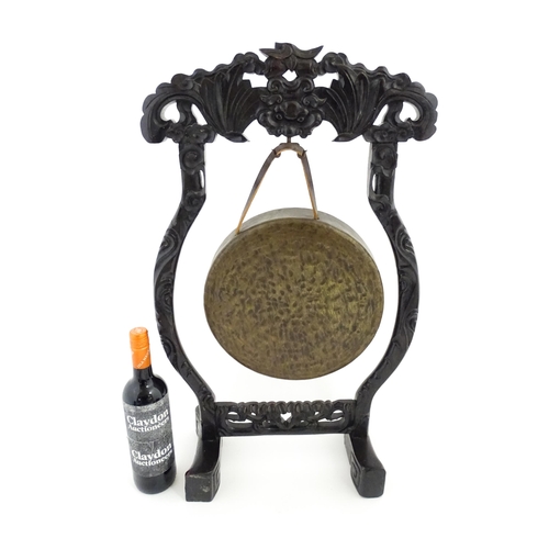 1274 - A 20thC Chinese gong and beater, the carved hardwood stand with central mask detail and scrolling st... 