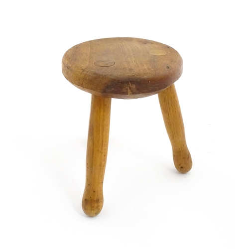 1285 - A 20thC fruitwood model of a milking stool. Approx. 6 1/4