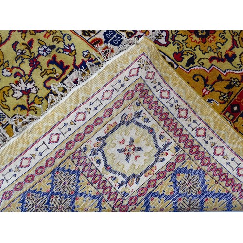 1503 - Carpet / Rug : A yellow and ochre ground rug with blue, red and white floral and foliate decoration,... 