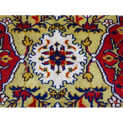 1503 - Carpet / Rug : A yellow and ochre ground rug with blue, red and white floral and foliate decoration,... 