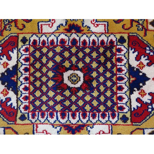 1503 - Carpet / Rug : A yellow and ochre ground rug with blue, red and white floral and foliate decoration,... 