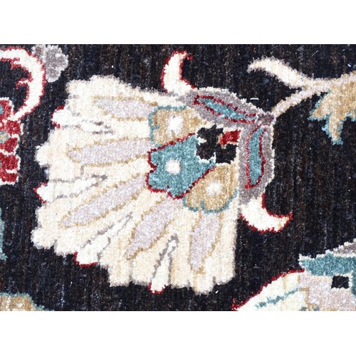 1506 - Carpet / Rug : A cream and black ground rug decorated with central medallion bordered by scrolling f... 