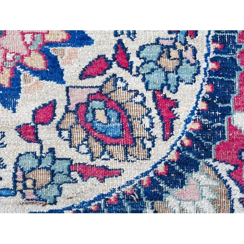 1507 - Carpet / Rug: A blue ground carpet with central cream and red floral motif bordered by scrolling fol... 