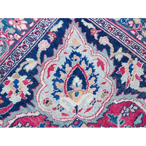 1507 - Carpet / Rug: A blue ground carpet with central cream and red floral motif bordered by scrolling fol... 