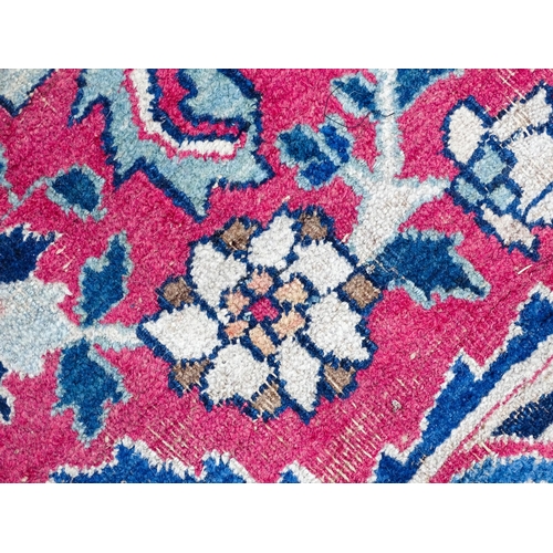 1507 - Carpet / Rug: A blue ground carpet with central cream and red floral motif bordered by scrolling fol... 