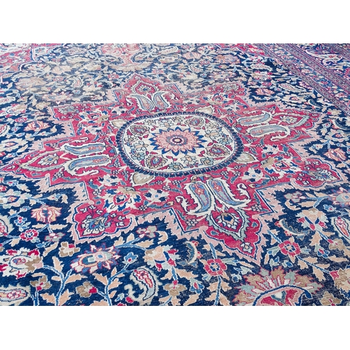 1507 - Carpet / Rug: A blue ground carpet with central cream and red floral motif bordered by scrolling fol... 